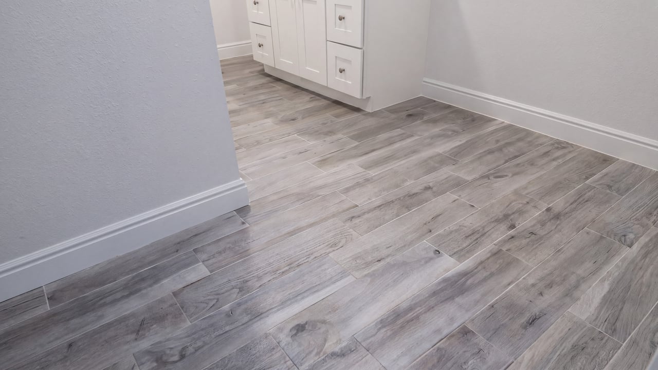 Pale wood-look bathroom flooring alongside a white vanity
