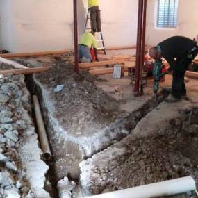 Construction company in Denver fixing pipes under concrete floors